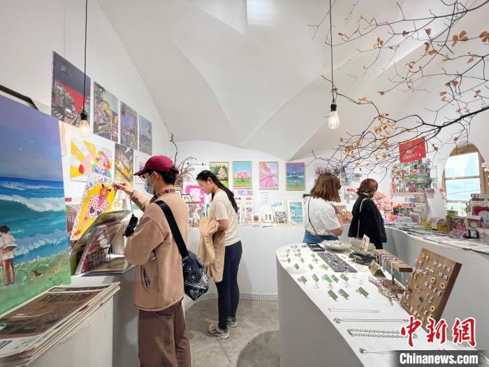 圖為藝術(shù)品商店內(nèi)，顧客挑選插畫作品。　鐘旖 攝