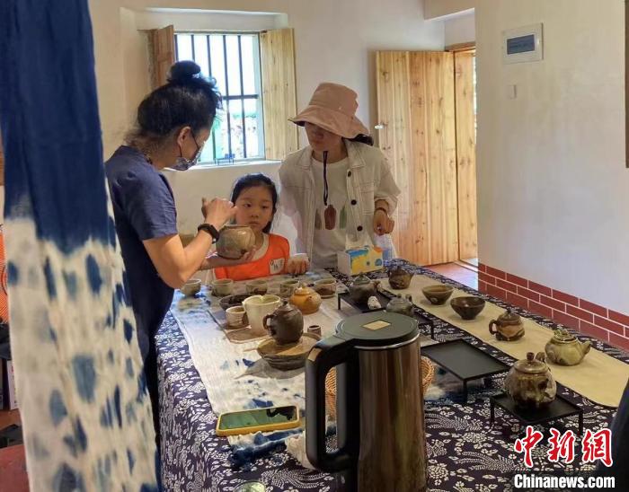 圖為：游客正在咨詢臺(tái)灣柴燒作品?！∪~秋云 攝