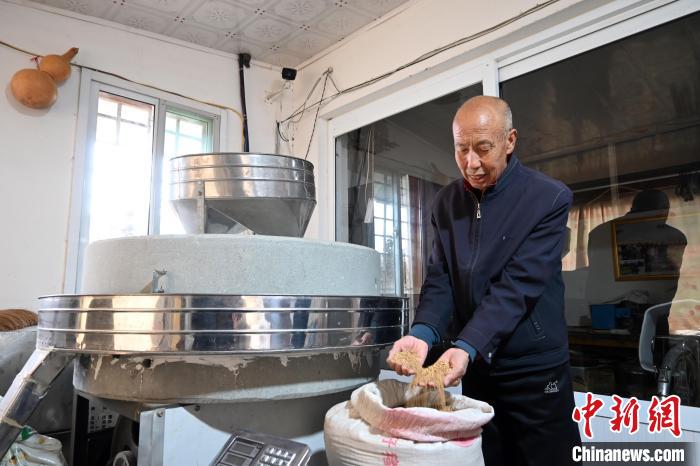 李家莊村民谷文朝重拾父輩的手藝，做起石磨面粉的營生?！〉杂鸺?攝
