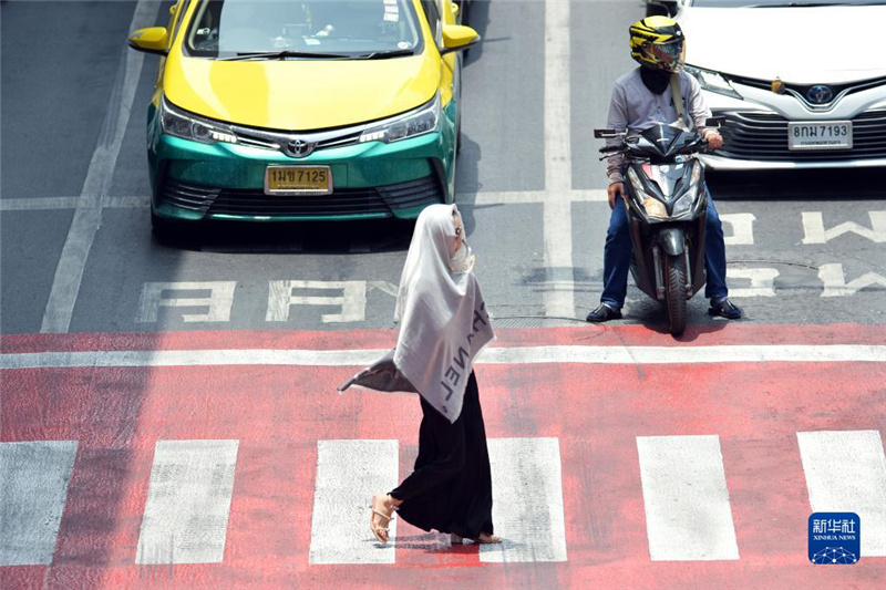 5月17日，行人在泰國曼谷街頭用圍巾遮陽。新華社發(fā)（拉亨攝）