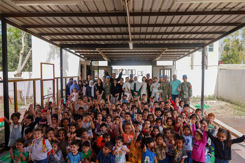 當?shù)貢r間5月30日，黎巴嫩南部庫雷拉公立小學，“六一”國際兒童節(jié)前夕，中國第21批赴黎維和多功能工兵分隊官兵看望慰問學校師生，并開展文化交流活動，圖為我維和官兵同師生合影。李竹林攝
