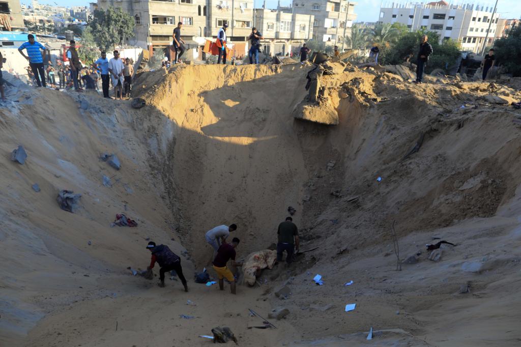 10月16日，在加沙地帶南部城市汗尤尼斯，人們?cè)谠庖陨幸u擊后的建筑廢墟中救援傷者。 新華社發(fā)（亞西爾·庫(kù)迪 攝）