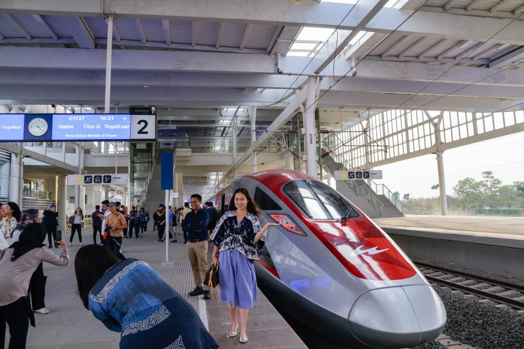 10月17日，在印度尼西亞萬隆德卡魯爾站，乘客在站臺上和雅萬高鐵高速動車組列車合影。
