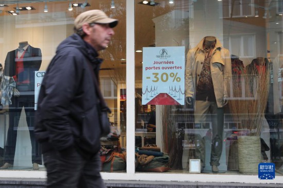   10月31日，一名男子從比利時布魯塞爾一家貼有打折信息的店鋪前走過。新華社記者 趙丁喆 攝
