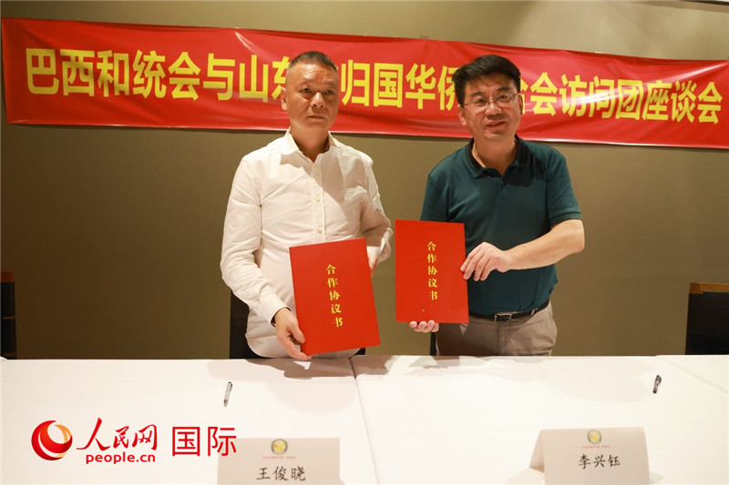 中國僑聯(lián)副主席、山東省僑聯(lián)主席李興鈺（右）與巴西和統(tǒng)會會長王俊曉簽署合作協(xié)議書。人民網(wǎng)記者 陳海琪攝