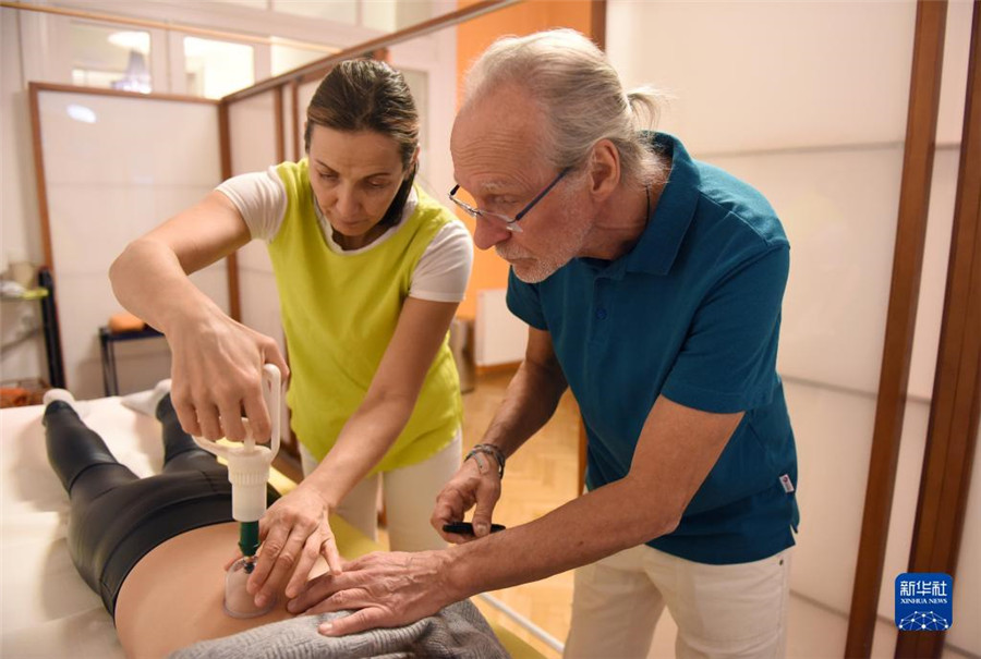 12月12日，在奧地利維也納，科格勒醫(yī)生（右）和助手在為病人進(jìn)行拔罐治療。新華社記者 賀燦鈴 攝