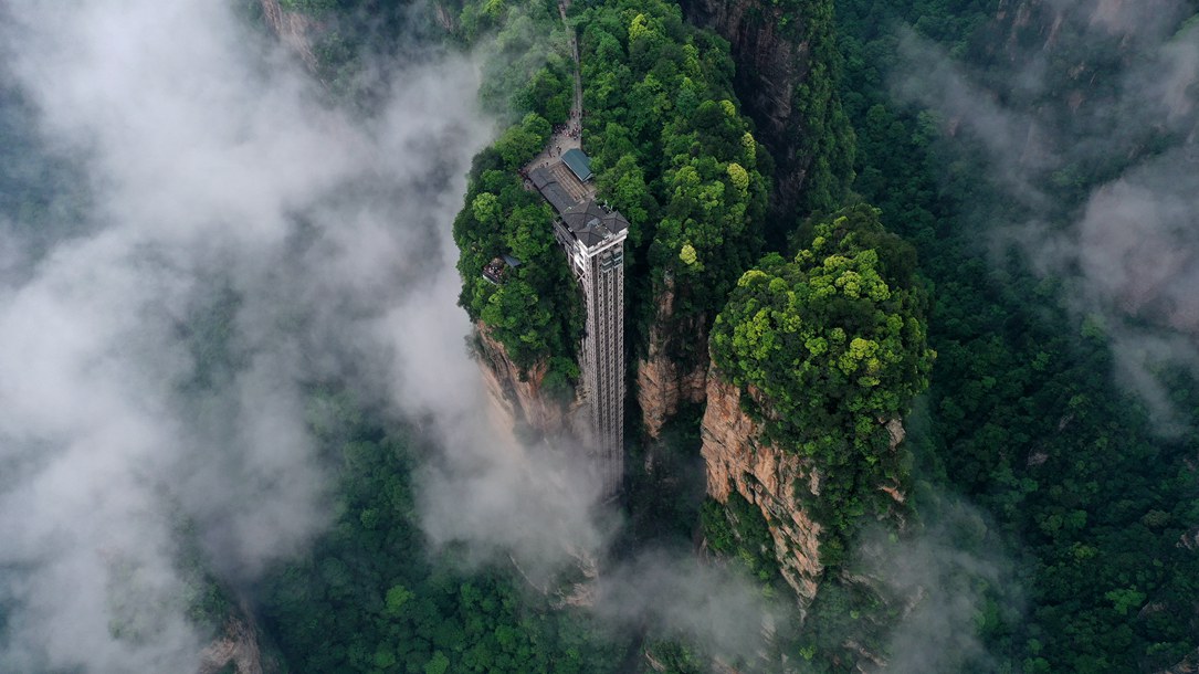 位于張家界武陵源景區(qū)的百龍?zhí)焯蓁偳对谠旗F繚繞的峰林間，雄偉壯觀。吳勇兵攝