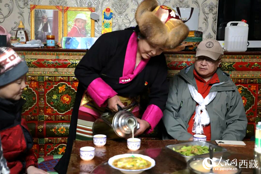 扎西曲登社區(qū)的居民在家中熱情招待遠(yuǎn)道而來的游客。居民身著盛裝，為游客倒上熱騰騰的酥油茶，桌上擺放著切瑪與特色美食，賓主共話民族團(tuán)結(jié)情誼。人民網(wǎng)記者 吳雨仁攝