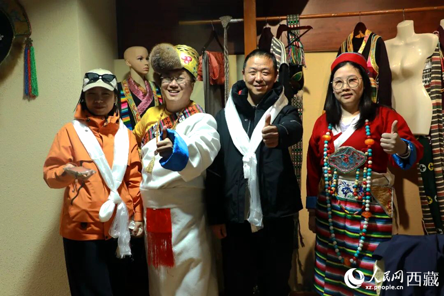游客在扎西曲登社區(qū)體驗藏族服飾文化。大家身著色彩鮮艷的藏裝，佩戴特色飾品，臉上洋溢著喜悅的笑容。人民網(wǎng)記者 吳雨仁攝