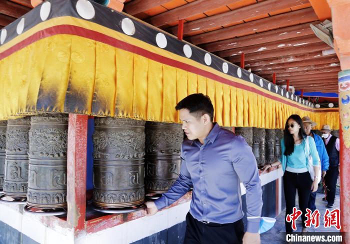 圖為外籍嘉賓體驗(yàn)藏族傳統(tǒng)轉(zhuǎn)經(jīng)筒?！●R銘言 攝