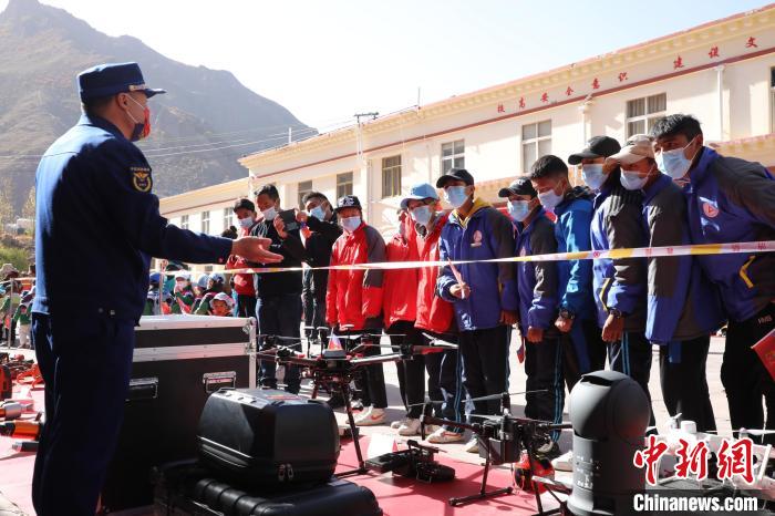 圖為消防指戰(zhàn)員為學(xué)生講解、演示先進(jìn)救援裝備?！≮w琳 攝