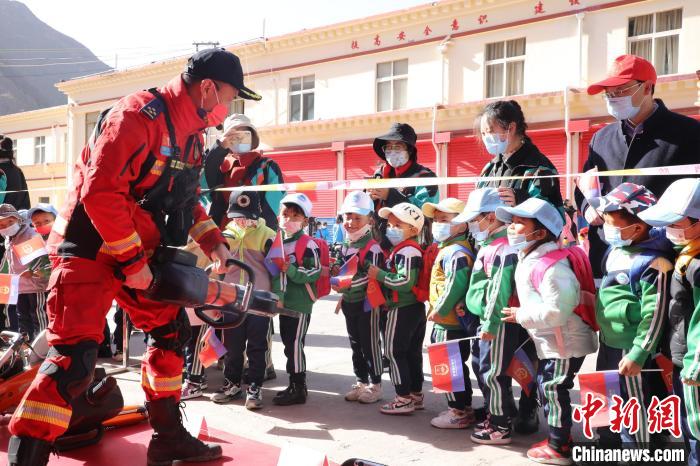 圖為消防指戰(zhàn)員為學(xué)生講解、演示先進(jìn)救援裝備。　趙琳 攝