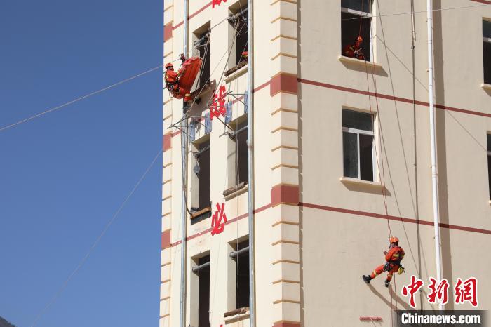 圖為消防指戰(zhàn)員進(jìn)行繩索救援演練。　朱科熹 攝