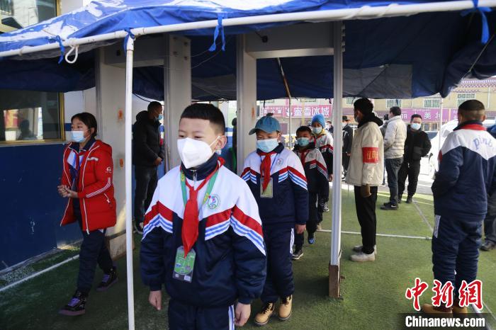 圖為學(xué)生測(cè)量體溫后進(jìn)入校園?！●R銘言 攝