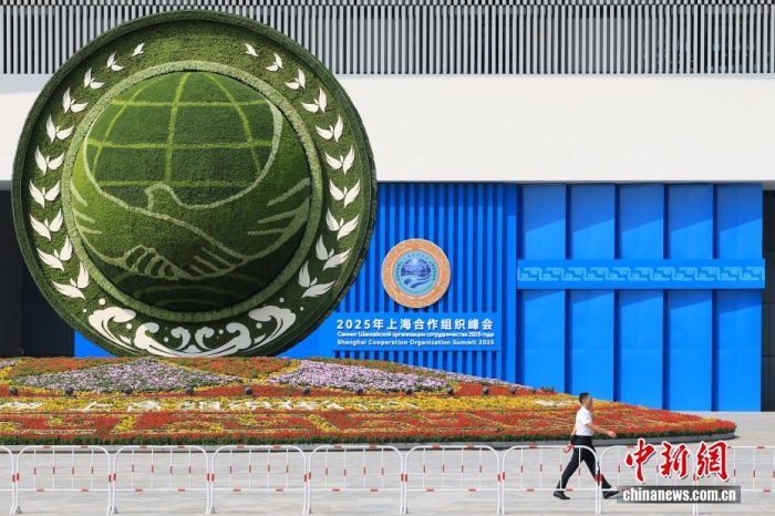 8月31日，天津，一名工作人員從2025年上海合作組織峰會(huì)主會(huì)場(chǎng)外的景觀花壇旁經(jīng)過。當(dāng)日，2025年上海合作組織峰會(huì)在天津舉行。<a target='_blank' href='/'><p  align=