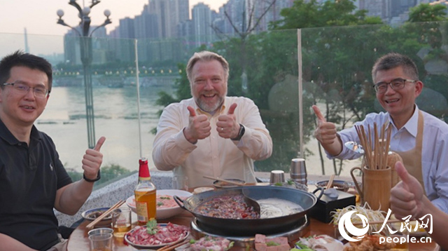 康寧顯示科技事業(yè)部全球拓建項(xiàng)目總監(jiān)軻寶華（中）和同事在重慶南濱路吃火鍋。人民網(wǎng)記者 蘇纓翔攝