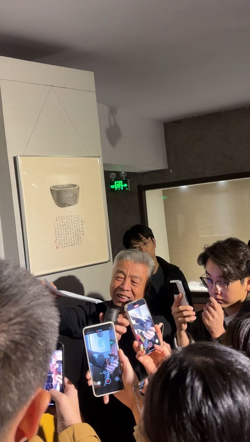 黑陶邢文化博物館館長邢葆東展示兩張相疊的A4紙，向記者解釋此為杯口的厚度。