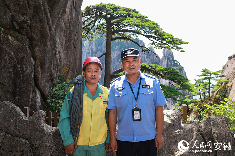 全國(guó)道德模范李培生（左）和胡曉春在迎客松前合影。人民網(wǎng)記者 張俊攝