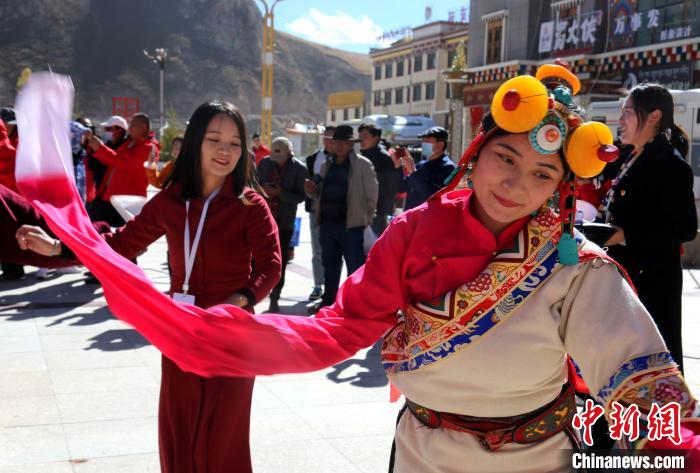 圖為中外記者向當?shù)孛癖妼W習民族歌舞文化?！?zhí)砀?攝