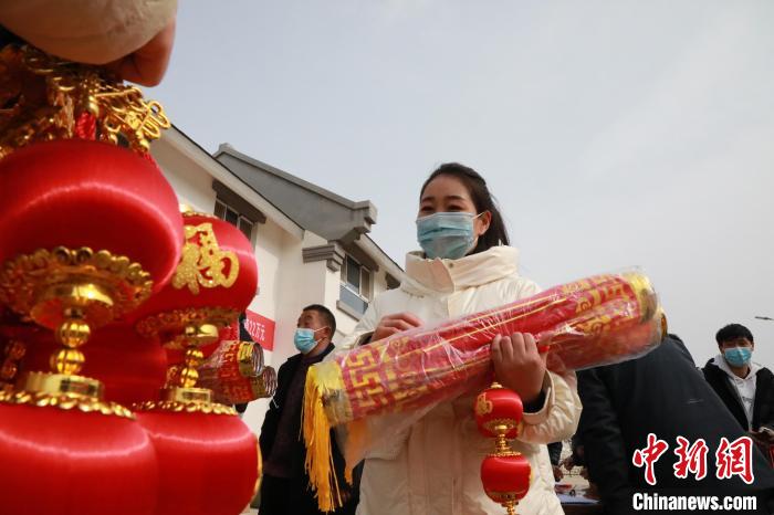 27日，蘭州新區(qū)為舟曲避險(xiǎn)搬遷移民送“春節(jié)包”，楊周馬草前往領(lǐng)取，紅色寓意來年的日子紅紅火火?！∥航ㄜ?攝