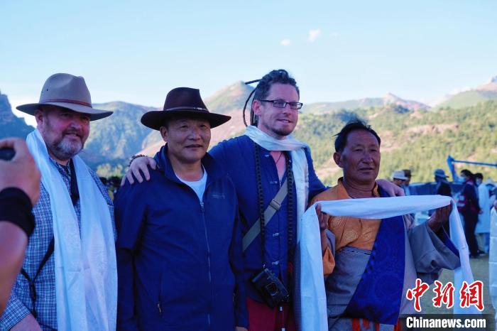 圖為當?shù)孛癖娕c外籍攝影師合影留念?！●R銘言 攝