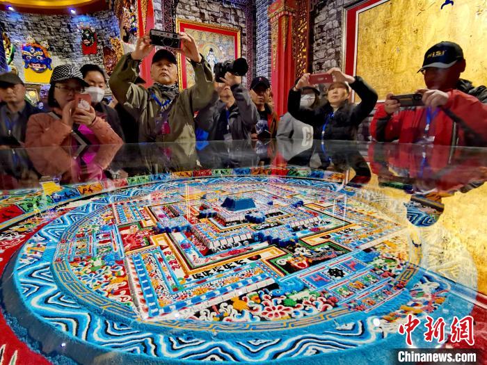 圖為參觀者拍攝壇城?！?zhí)砀?攝