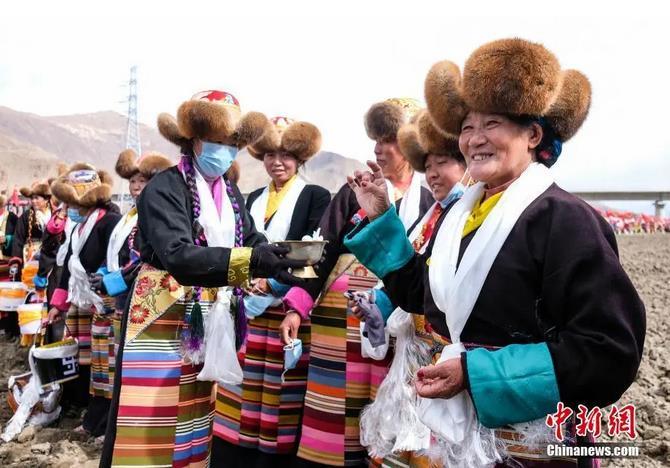 資料圖：西藏自治區(qū)拉薩市曲水縣才納鄉(xiāng)協(xié)榮村參加春耕儀式的村民互敬青稞酒。按照傳統(tǒng)，當?shù)卮迕裆碇?jié)日盛裝，舉行隆重的儀式，祈福一年的豐收。<a target='_blank' ><p  align=