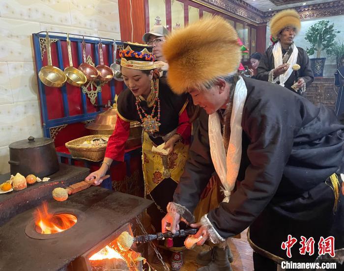 圖為人們在火上烤節(jié)日美食“結(jié)達(dá)”。　冉文娟 攝