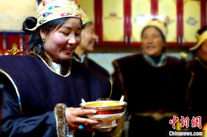圖為藏族姑娘向客人敬酒?！∪轿木?攝