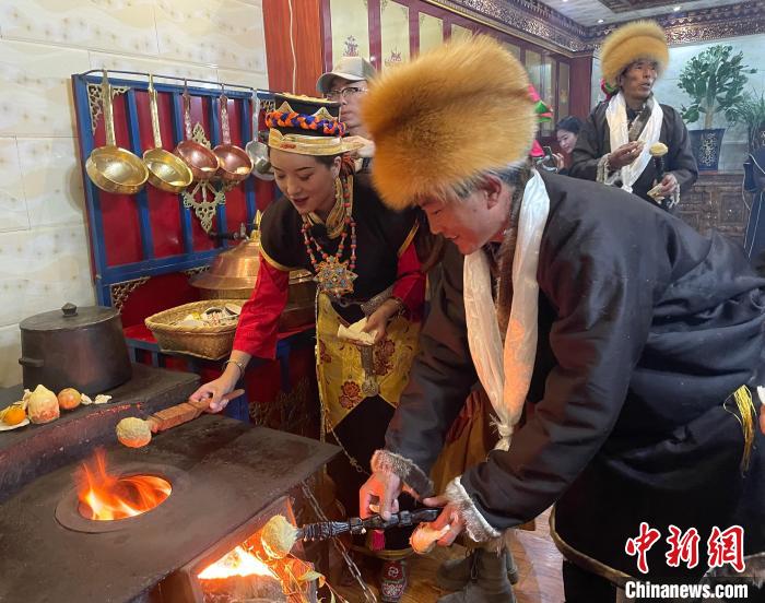 圖為人們在火上烤節(jié)日美食“結(jié)達(dá)”。　冉文娟 攝