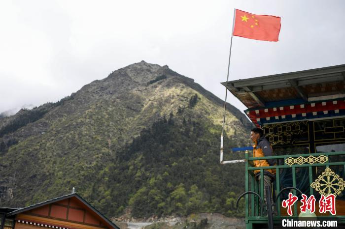 村民站在樓房上觀望?！钊A峰 攝