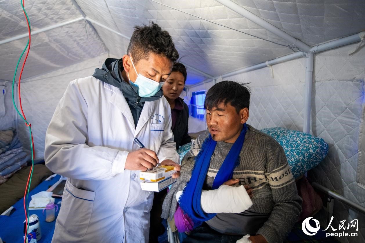 　醫(yī)生正在囑咐洛桑堅參如何用藥。人民網(wǎng)記者 翁奇羽攝