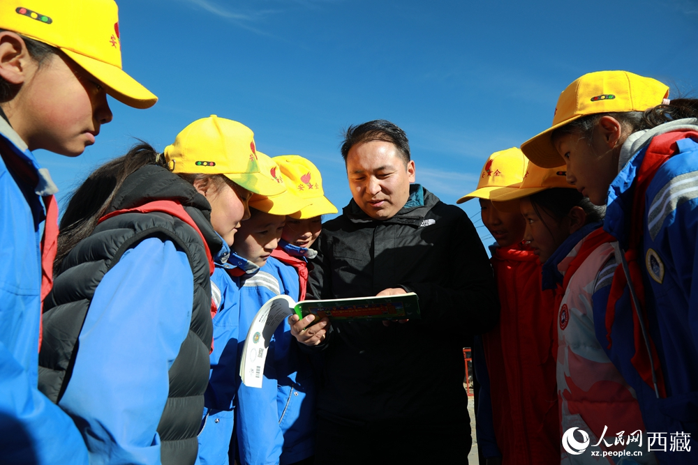 西藏自治區(qū)藏醫(yī)院專家為拉東村小學(xué)生講解天文歷算原理，孩子們圍站聆聽，感受傳統(tǒng)智慧與現(xiàn)代科普的融合。人民網(wǎng)記者 吳雨仁攝