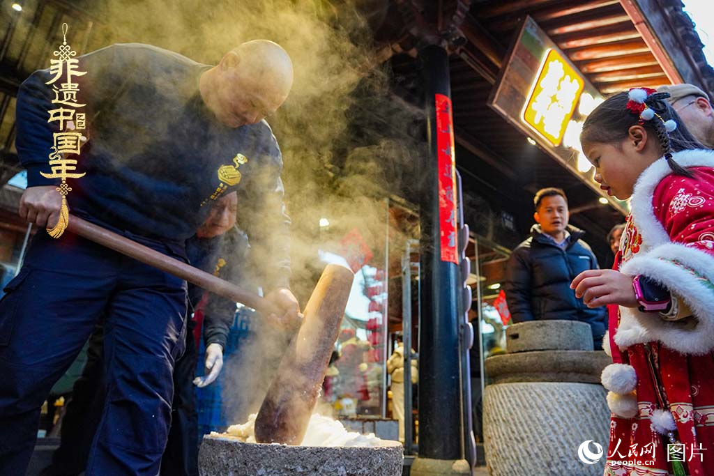 2025年1月29日，浙江省寧波市江北區(qū)慈城古縣城，市民和游客觀看搗年糕。人民網(wǎng) 章勇濤攝