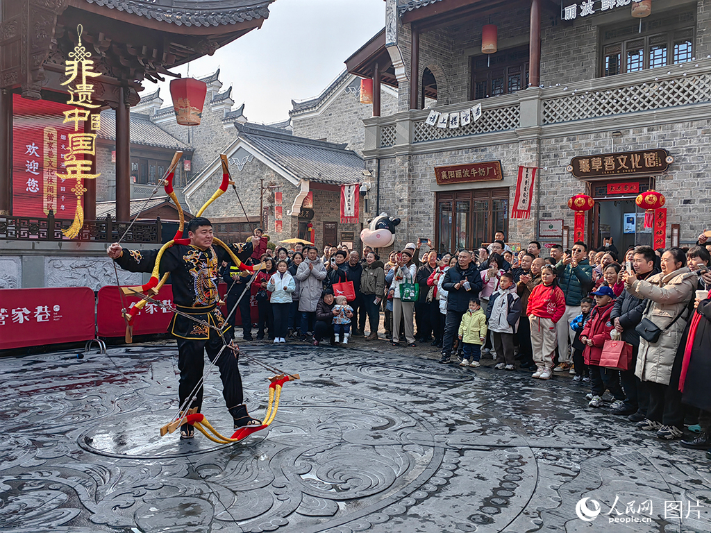 2025年1月29日，湖北襄陽市管家巷，老北京天橋大刀張舉大刀拉硬弓第五代傳承人現(xiàn)場表演，一次拉開6張弓，引來游客喝彩。人民網(wǎng)記者 郭婷婷攝