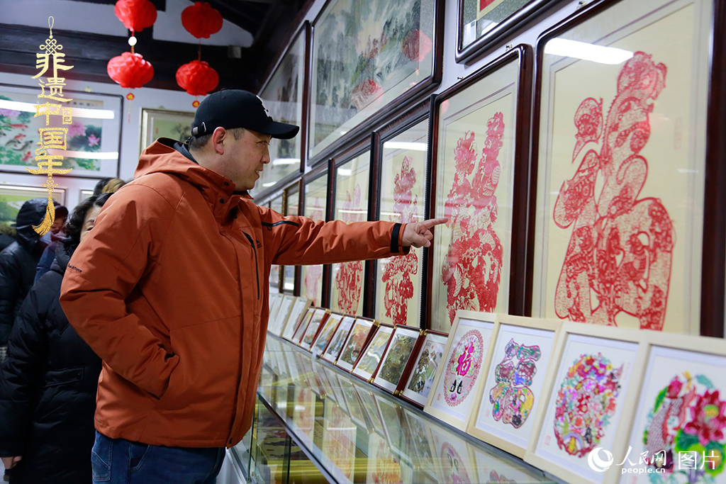 2025年1月23日，游客在天津楊柳青古鎮(zhèn)欣賞傳統(tǒng)剪紙作品，感受指尖上的古老藝術(shù)。人民網(wǎng)記者 崔新耀攝