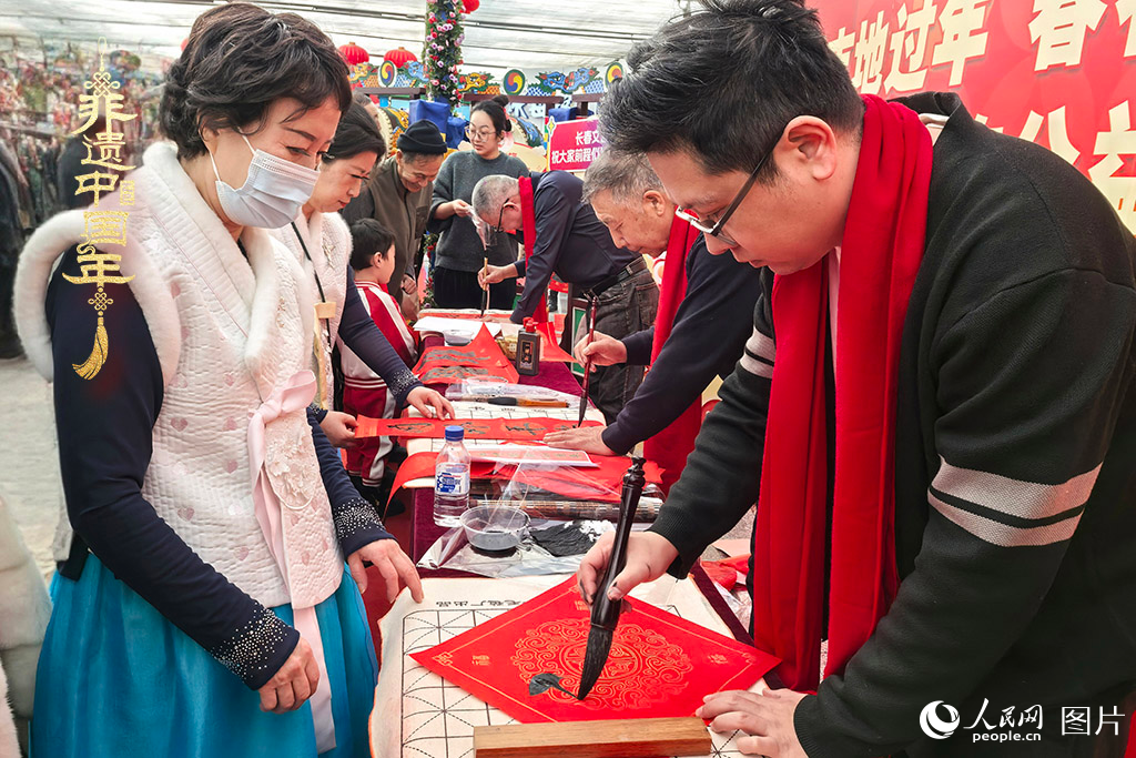 新春佳節(jié)之際，長春農(nóng)博園冬季展會火熱進行，展廳內(nèi)，書法家現(xiàn)場書寫“福”字，市民游客紛紛上前迎春接“?！?。人民網(wǎng)記者 王海躍攝