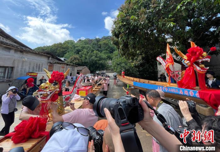 圖為5月29日，長(zhǎng)樂江田鎮(zhèn)村民為即將入水的新龍舟安裝龍頭?！埍?攝