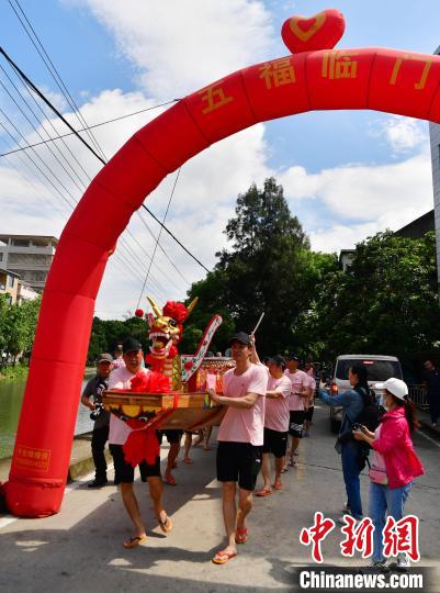 圖為5月29日，長(zhǎng)樂江田鎮(zhèn)村民們推著新龍舟前行?！埍?攝