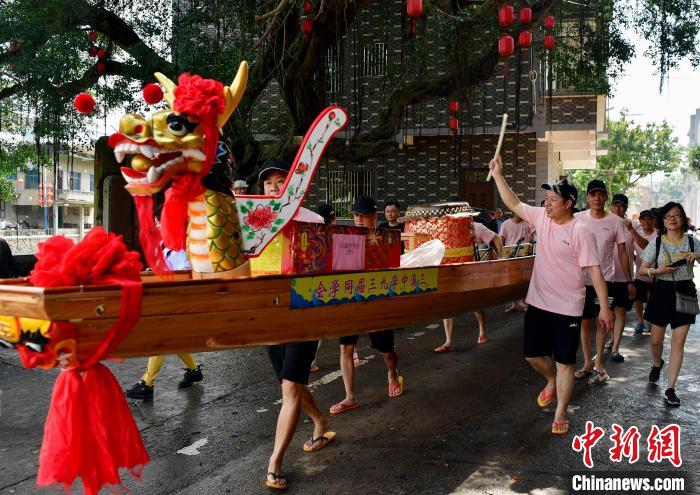 圖為5月29日，長(zhǎng)樂江田鎮(zhèn)村民們推著新龍舟前行。　張斌 攝