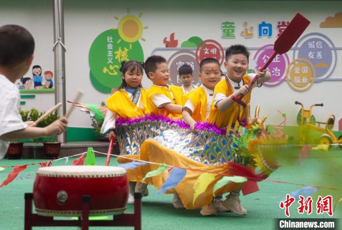 圖為龍舟賽游戲上，小伙伴們打鼓加油?！《^生 攝